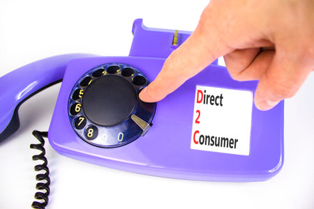 DTC direct 2 consumer symbol. Concept words DTC direct 2 consumer on beautiful old disk phone. Beautiful white background. Businessman hand. Business DTC direct 2 consumer concept. Copy space.