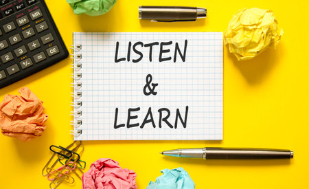 Listen and learn words symbol. Concept words Listen and learn on beautiful white note. Beautiful yellow background. Black pen. Black calculator. Business listen and learn support concept. Copy space.