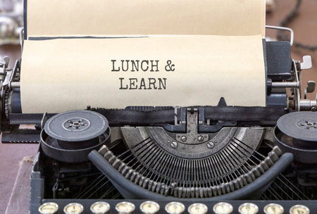 Lunch and learn symbol. Concept words Lunch and learn typed on beautiful old retro typewriter. Beautiful white paper background. Business, educational and lunch and learn concept. Copy space.