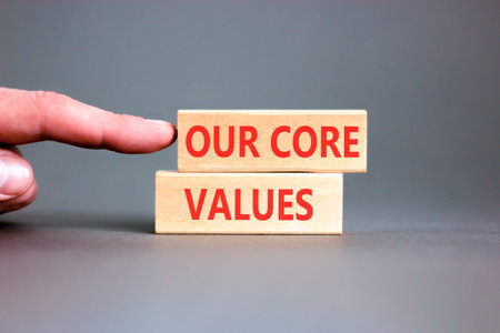Our core values words symbol. Concept words Our core values on beautiful wooden blocks. Beautiful grey background. Businessman hand. Business our core values motivational support concept. Copy space