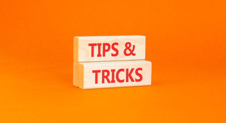 Tips and tricks words symbol. Concept words Tips and tricks on beautiful wooden blocks. Beautiful orange background. Business tips and tricks motivational support concept. Copy space.