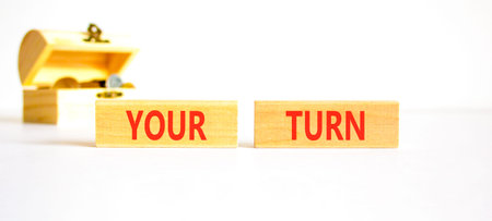 Your turn words symbol. Concept words Your turn on beautiful wooden blocks. Beautiful white background. Wooden chest with coins. Business your turn motivational support concept. Copy space.