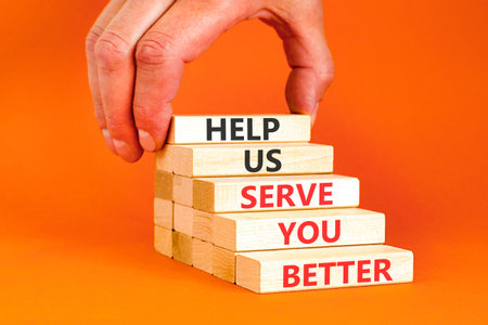 Help us serve you better symbol. Concept words Help us serve you better on beautiful wooden blocks. Beautiful orange background. Business and help us serve you better concept. Copy space.