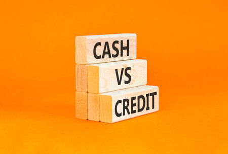 Cash vs credit words symbol. Concept words Cash vs credit on beautiful wooden blocks. Beautiful orange background. Business and cash vs credit concept. Copy space.