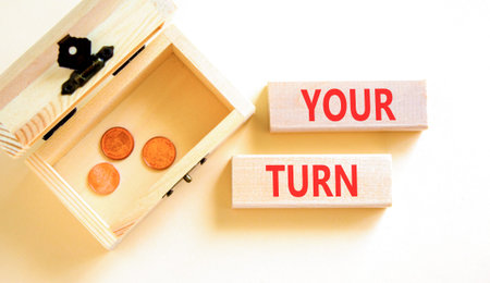 Your turn words symbol. Concept words Your turn on beautiful wooden blocks. Beautiful white background. Wooden chest with coins. Business your turn motivational support concept. Copy space.