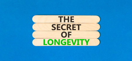 The secret of longevity words symbol. Concept words The secret of longevity on beautiful wooden sticks. Beautiful blue background. Psychological medical the secret of longevity concept. Copy space.