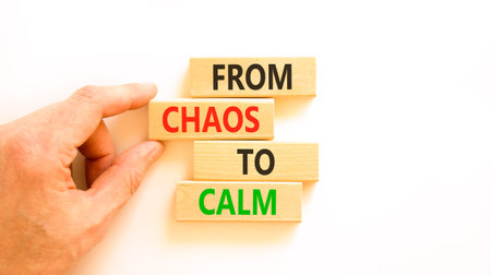 From chaos to calm symbol. Concept words From chaos to calm on beautiful wooden blocks. Beautiful white background. Businessman hand. Business psychological from chaos to calm concept. Copy space.