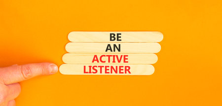 Be an active listener words symbol. Concept words Be an active listener on beautiful wooden sticks. Beautiful orange background. Businessman hand. Business be an active listener concept. Copy space.