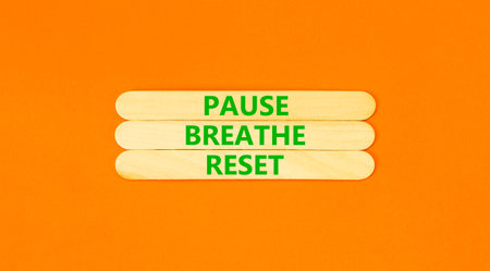 Pause breathe reset words symbol. Concept words Pause breathe reset on beautiful wooden sticks. Beautiful orange background. Business support motivational and pause breathe reset concept. Copy space.