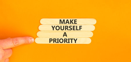 Make yourself a priority symbol. Concept words Make yourself a priority on beautiful wooden sticks. Beautiful orange background. Business psychological make yourself a priority concept. Copy space.