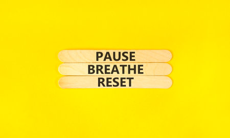 Pause breathe reset words symbol. Concept words Pause breathe reset on beautiful wooden sticks. Beautiful yellow background. Business support motivational and pause breathe reset concept. Copy space.
