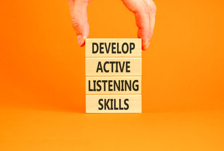 Develop active listening skills symbol. Concept words Develop active listening skills on beautiful wooden blocks. Beautiful orange background. Business active listening skills concept. Copy space.