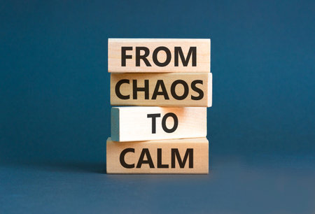 From chaos to calm symbol. Concept words From chaos to calm on beautiful wooden blocks. Beautiful grey background. Business psychological from chaos to calm concept. Copy space.