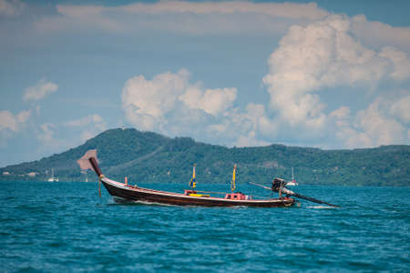 Picture of small fishing boat floating near coast line on a bright sunny day. Ko Bon, Thailand.の写真素材