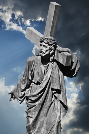 Jesus Christ carries the cross on the background of dramatic clouds  The statue is set in Lviv, in the courtyard of Armenian Cathedral in 1881, the author - T  Dykas の写真素材