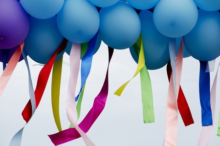 Blue balloons with developing colorful ribbons の写真素材
