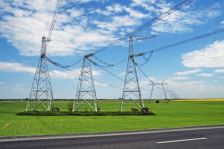 Transmission lines on a background a grass and roadの写真素材