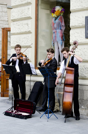 LVIV, UKRAINE - JUNE 13, 2012: Street musicians in the center of Lvov entertain tourists, who came to the UEFA EURO-2012. In Lviv are held football matches EURO-2012.のeditorial素材