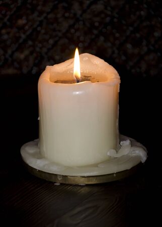 Decorative candle burning on a dark backgroundの写真素材