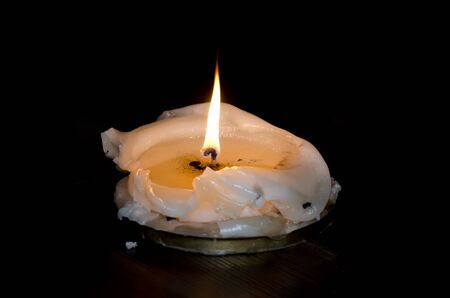 Decorative candle burning on a black backgroundの写真素材