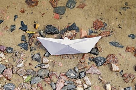 Paper boat lying on the shore after the crashの写真素材