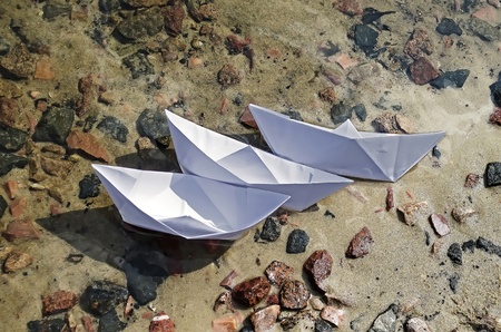 Paper boats lying on the shore after the crashの写真素材