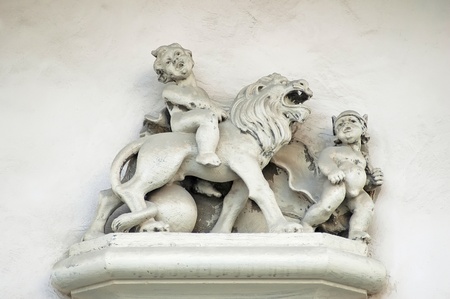 Boy sitting astride a lion on the old building in Lvov, Ukraineの写真素材