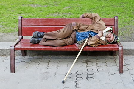 LVOV, UKRAINE - MAY 25: During the Euro 2012 in Lviv, from main streets disappeared homeless on May 25, 2012 in Lvov, Ukraine. On photo unknown homeless man sleeping on a bench.のeditorial素材