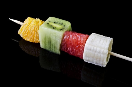 Fruit snacks on a bamboo stick, isolated on a black backgroundの写真素材