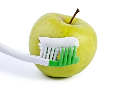 Toothbrush with toothpaste and green apple close-up, isolated on a white backgroundの写真素材