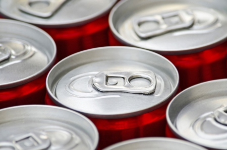 Many aluminum red cans of soft drink cola close-up