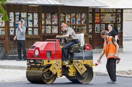 LVOV, UKRAINE - APRIL 27: Road roller compacted asphalt during the repair on the main street of Lvov on April 27, 2013 in Lviv, Ukraineのeditorial素材