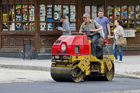 LVOV, UKRAINE - APRIL 27: Road roller compacted asphalt during the repair on the main street of Lvov on April 27, 2013 in Lviv, Ukraineのeditorial素材