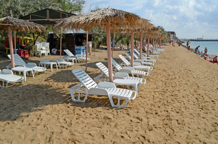 FEODOSIA, CRIMEA, RUSSIA - SEPTEMBER 03:  People have a rest, bathe and sunbathe on equipped chaise lounges and beach umbrellas a beach on September 03, 2013 in Feodosia, Crimea, Russiaのeditorial素材