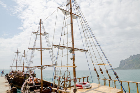 KOKTEBEL, CRIMEA, RUSSIA - JUNE 08  Pleasure yacht with tourists on the pier in Koktebel on June 08, 2014 in Koktebel, Crimea, Russiaのeditorial素材