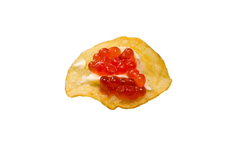 Red caviar on potato chips, isolated over whiteの写真素材