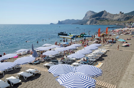 SUDAK, CRIMEA, RUSSIA - AUGUST 24: Tourists resting on the beach on august 24, 2014 in Sudak, Crimea, Russiaのeditorial素材