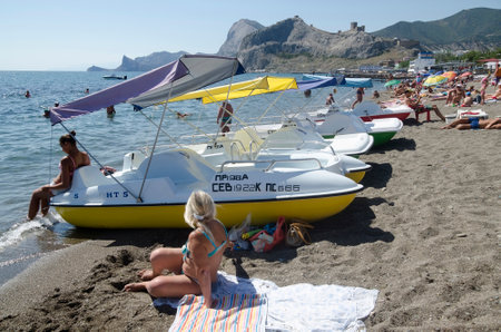 SUDAK, CRIMEA, RUSSIA - AUGUST 24: Attraction - water bikes in Sudak on august 24, 2014 in Sudak, Crimea, Russiaのeditorial素材