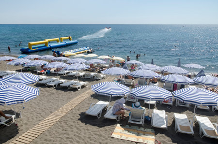 SUDAK, CRIMEA, RUSSIA - AUGUST 24: Resting under a sun umbrella on the beach on august 24, 2014 in Sudak, Crimea, Russiaのeditorial素材
