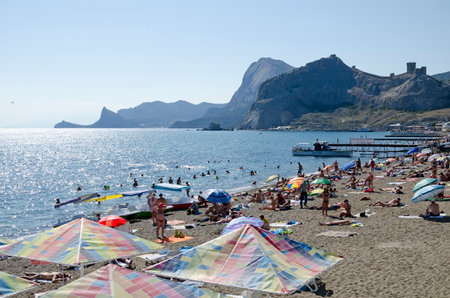 SUDAK, CRIMEA, RUSSIA - AUGUST 24: Tourists resting on the beach on august 24, 2014 in Sudak, Crimea, Russiaのeditorial素材
