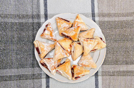 Delicious triangular cookies with filling on a plate close-upの写真素材