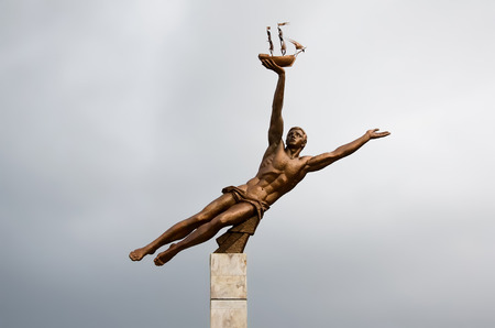 Monument to the shipbuilders on the square near the Palace of culture "Shipbuilder" - a sculpture of a man with a naked torso, holding a shipの写真素材