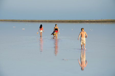 Children walk on the surface (the crust formed salt) salt Kojashsky lake in the Opuk nature reserveの写真素材