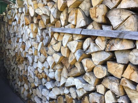 Stacked firewood (woodpile) for the stove in the open air close-upの写真素材