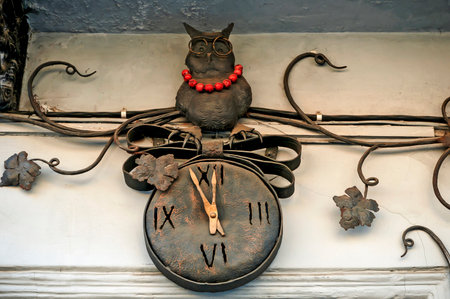 LVIV, UKRAINE - MARCH 30: A wrought-iron owl sitting on a clock on the facade of a building in the center of Lviv on March 30, 2011 in Lvov, Ukraineのeditorial素材