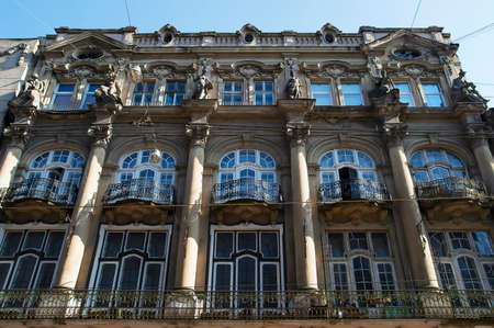 An old residential building in the center of Lviv, built in the neoclassical style, decorated with stucco, wrought-iron balconies and statuesの写真素材