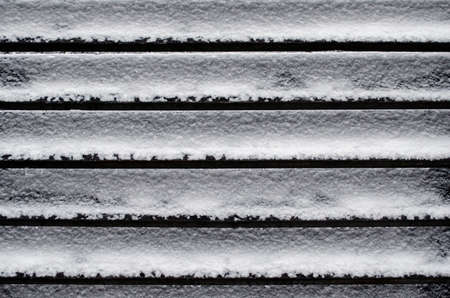 Wooden planks fence covered with snow close upの写真素材