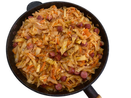 White cabbage stew with smoked pork sausages and tomato paste in a frying pan isolated on whiteの写真素材