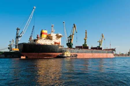 Big ship unloading in shipyard at day time with clear sky