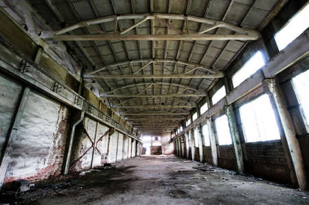 Old and deserted plant symmetrical interior with weathered walls and overlap